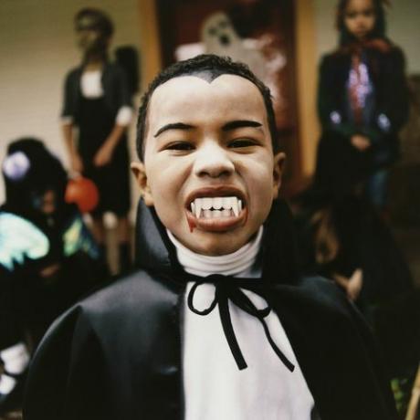 potret seorang anak laki-laki yang mengenakan kostum vampir