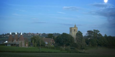 Pemandangan Goudhurst di Kent saat senja dengan gereja St Mary dan rumah-rumah oast