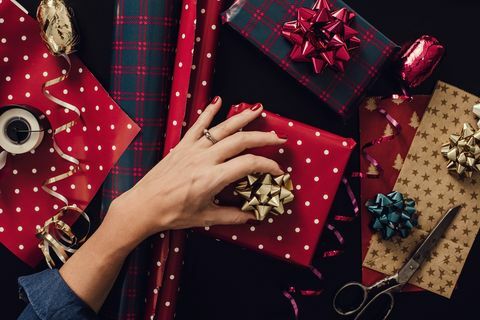 wanita membungkus kado natal mempersembahkan foto yang diambil dari atas atas. tembakan tangan kertas kado busur atas meja diambil langsung di atas