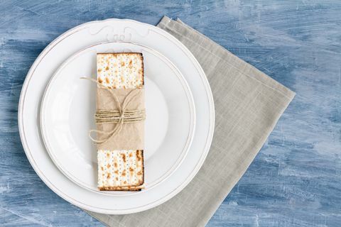 piring putih dengan matzah atau matza pada latar belakang meja antik disajikan sebagai pesta atau makanan seder paskah