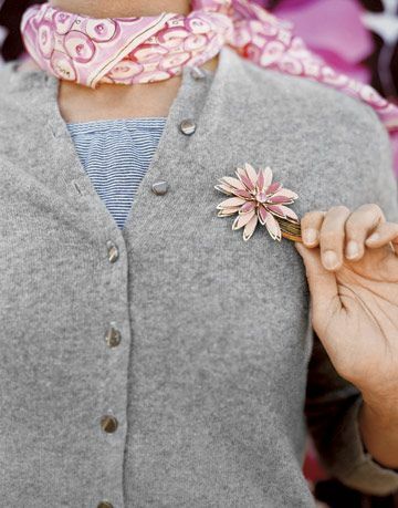 Sweater abu-abu dengan pin bunga merah muda