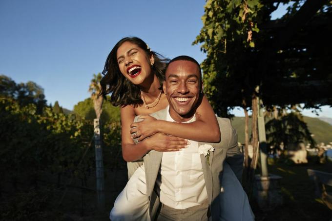 pria tertawa membonceng wanita di kebun anggur