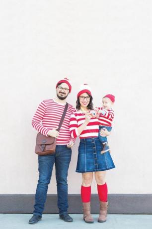 ibu, ayah dan bayi berdandan karakter waldo mana dengan kemeja garis-garis putih dan merah dan topi rajut