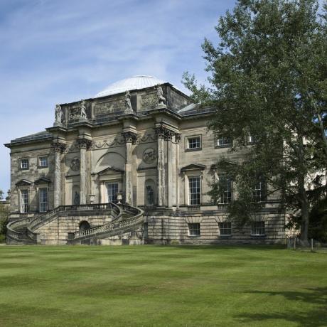 bagian depan selatan aula kedleston, derbyshire dengan gereja semua orang suci di sebelah kiri rumah ini dimulai pada tahun 1759 oleh paine dan brettingham, tetapi dengan robert adam mengambil desainnya oleh 1760 bagian depan selatan memiliki fitur sentral berdasarkan lengkungan Konstantinus, dikombinasikan dengan kubah rendah dari panteon gereja semua orang kudus berada di bawah pemeliharaan konservasi gereja memercayai