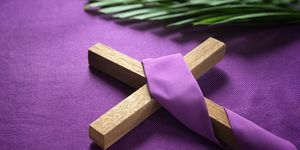 salib agama dan daun palem dengan latar belakang ungu