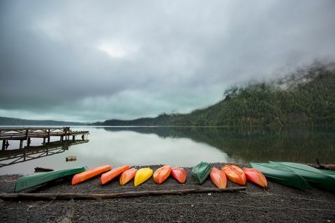 serangkaian kano penuh warna di sepanjang tepi danau