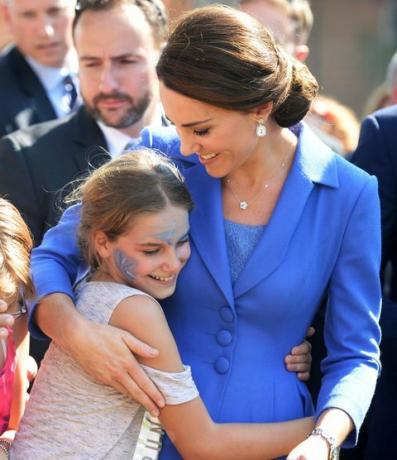 Duchess of Cambridge memeluk seorang anak ketika dia mengunjungi sebuah badan amal yang mendukung orang-orang muda dari latar belakang yang kurang beruntung di Berlin selama kunjungan resmi kerajaan ke Jerman