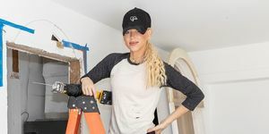 galey alix dari hgtv's home dalam sekejap berdiri di tangga mengenakan t-shirt jeans ball cap berceceran cat