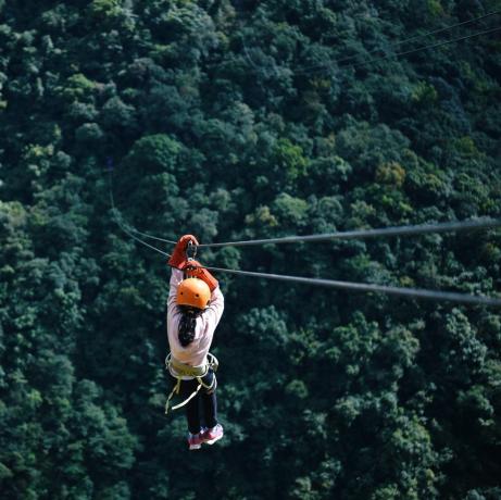 gadis ziplining di pegunungan