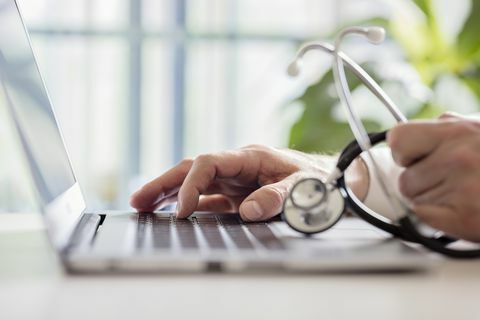Dokter memasukkan catatan pasien pada laptop dalam operasi