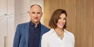 host hilary farr dan david visentin berdiri di dapur terbuka, tersenyum